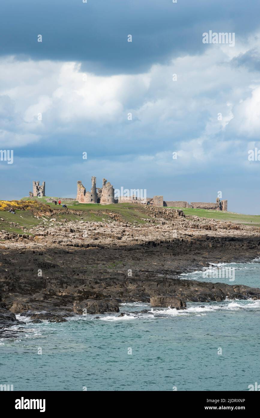 UK coast, view in dramatic light of the wild and rugged coast between Craster and Dunstanburgh Castle ruins on the Northumberland coast, England, UK Stock Photo
