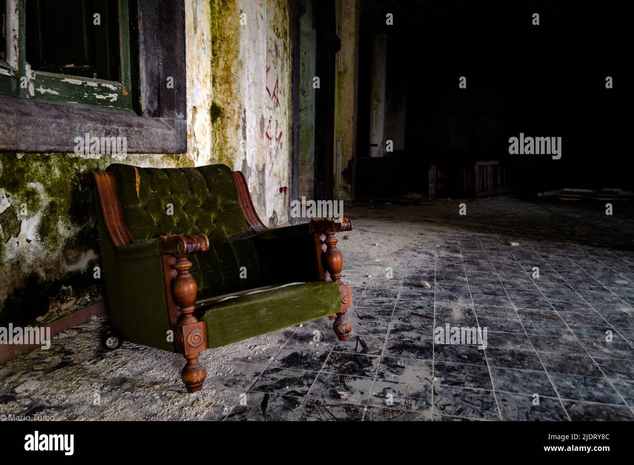 A green sofa in an abandoned building Stock Photo