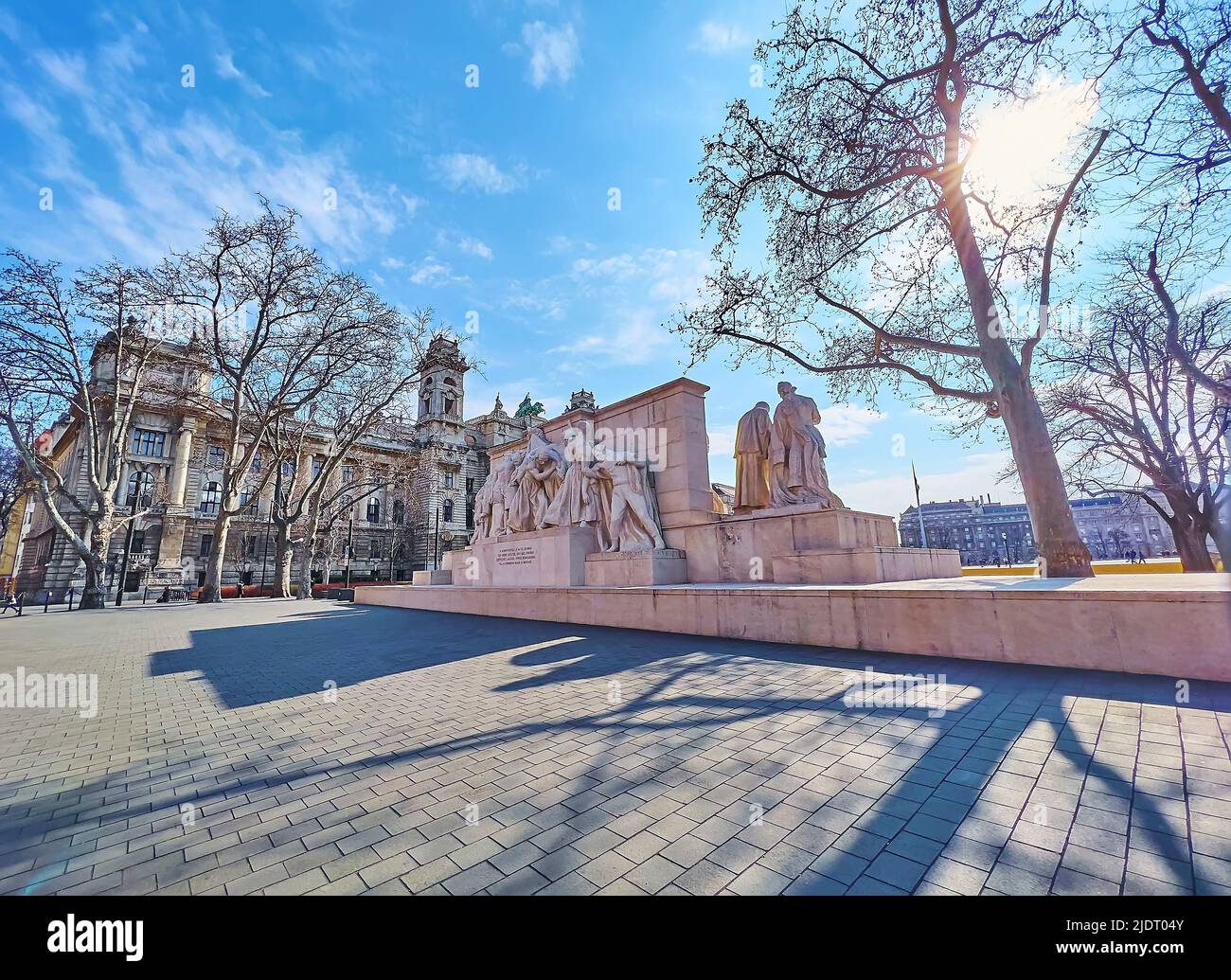 The sunny Lajos Kossuth Square with a view on complex stone Kossuth Memorial and building of Ethnographic Museum (Palace of Justice) in background, Bu Stock Photo