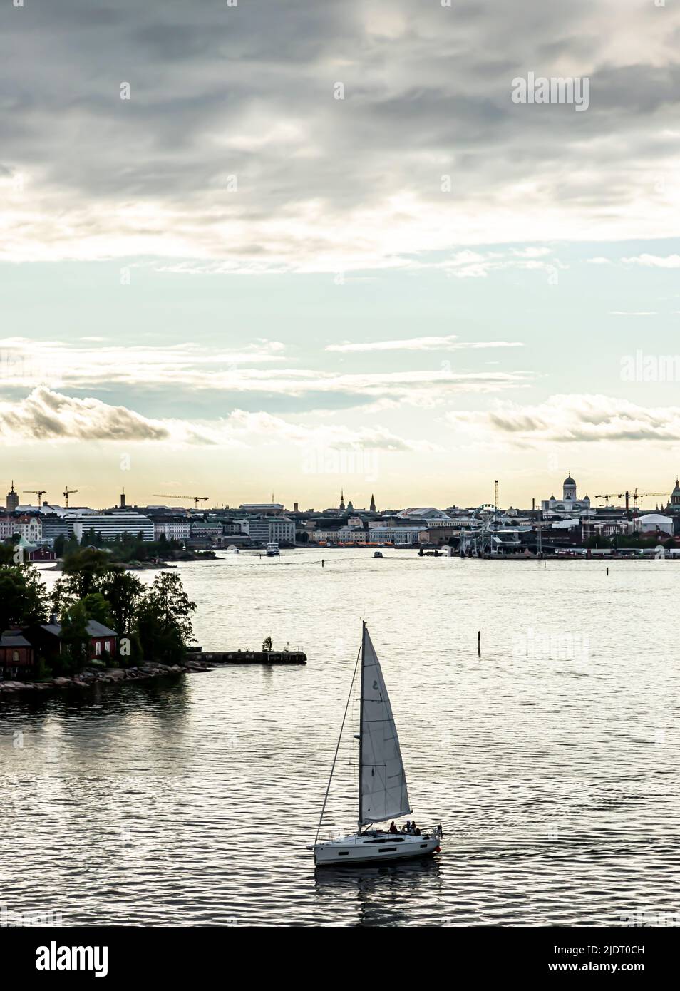 The South Harbour of Helsinki on a summer evening. A sailing boat in the foreground. Downtown Helsinki in the background. Room for text. Stock Photo