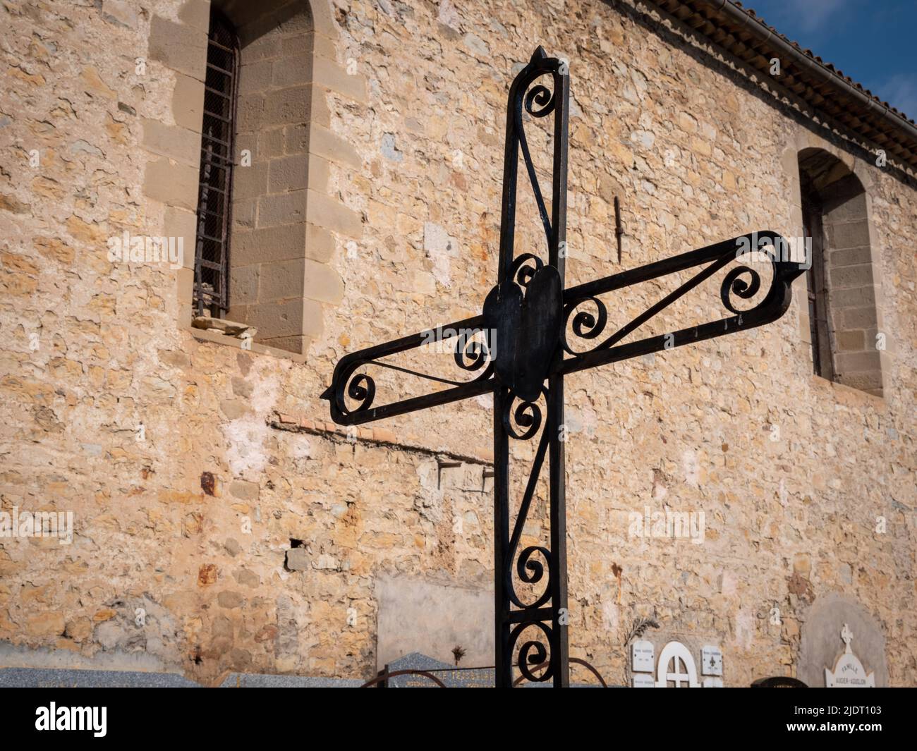 A wrought iron Christian cross in a cemetery adjoining the main church in the Provençal village of Villars-sur-Var in southeastern France Stock Photo