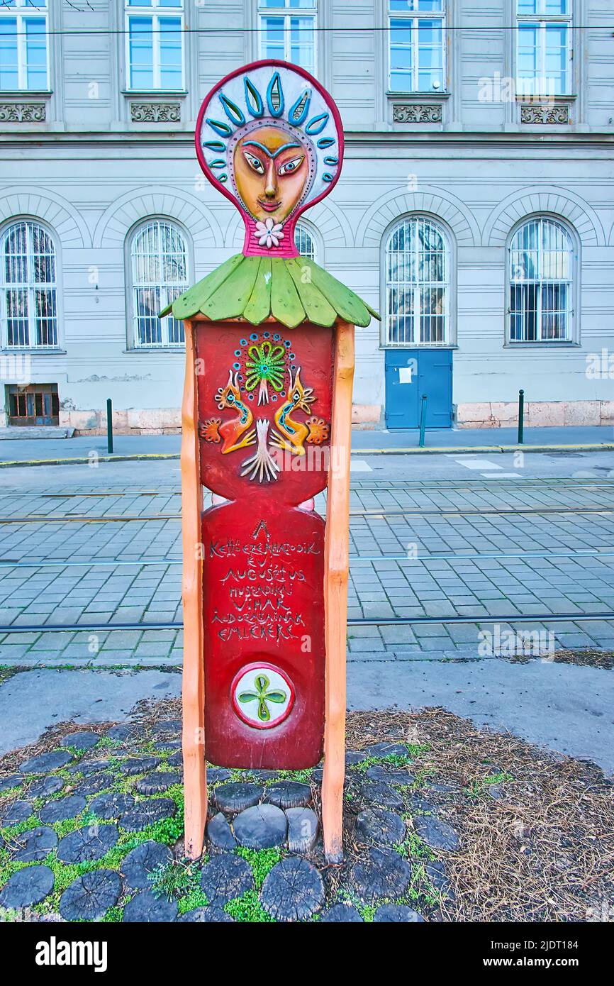 BUDAPEST, HUNGARY - FEB 27, 2022: The wooden sculpture in folk style is the Victims of August 2006 Assault Memorial on Bem Embankment of Danube River, Stock Photo