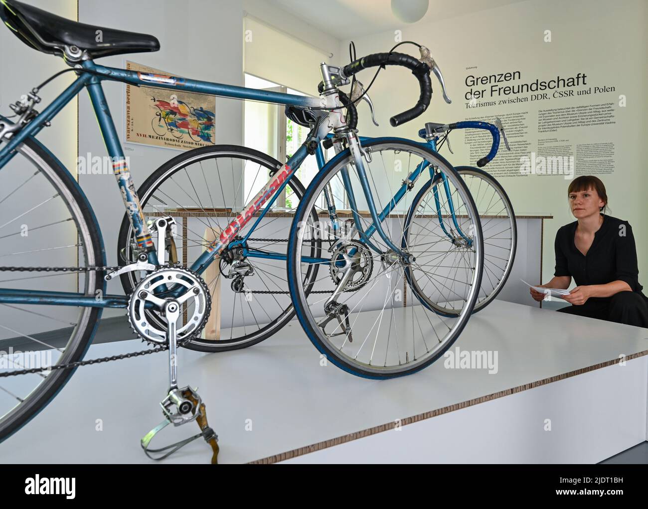 23 June 2022, Brandenburg, Eisenhüttenstadt: Florentine Nadolni, director of the Museum Utopia and Everyday Life, looks at racing bikes from the 1970s and 1980s at the press preview of the exhibition 'Borders of Friendship. Tourism between the GDR, CSSR and Poland' at the Documentation Center for Everyday Culture of the GDR. The 'Iron Curtain' ran through Europe during the Cold War, but the borders between the socialist 'friendship countries' were also a political issue and passable only to a limited extent. In the 1960s, they became somewhat more permeable, but 1972 marked a real breakthrough Stock Photo
