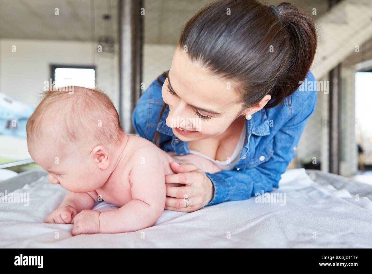 Happy mother and her newborn baby changing diapers on the changing table Stock Photo