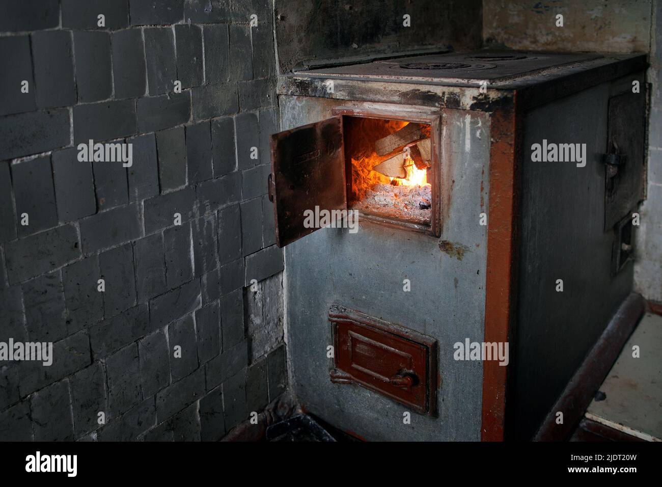 Old rural wood stove with the burning firewood Stock Photo