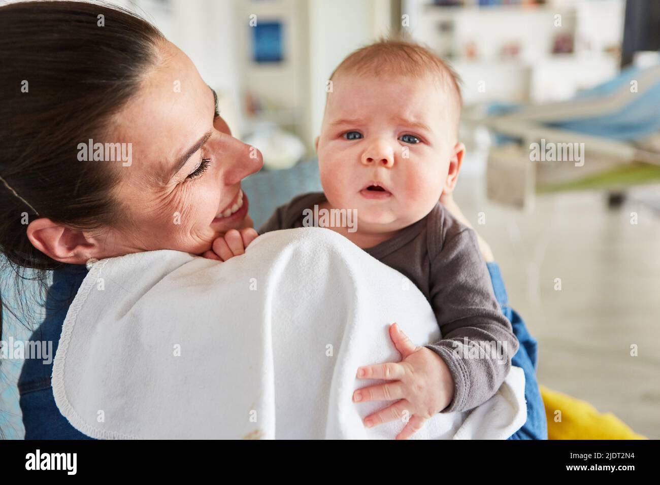 Happy smiling mother holding baby in her arms for maternity and