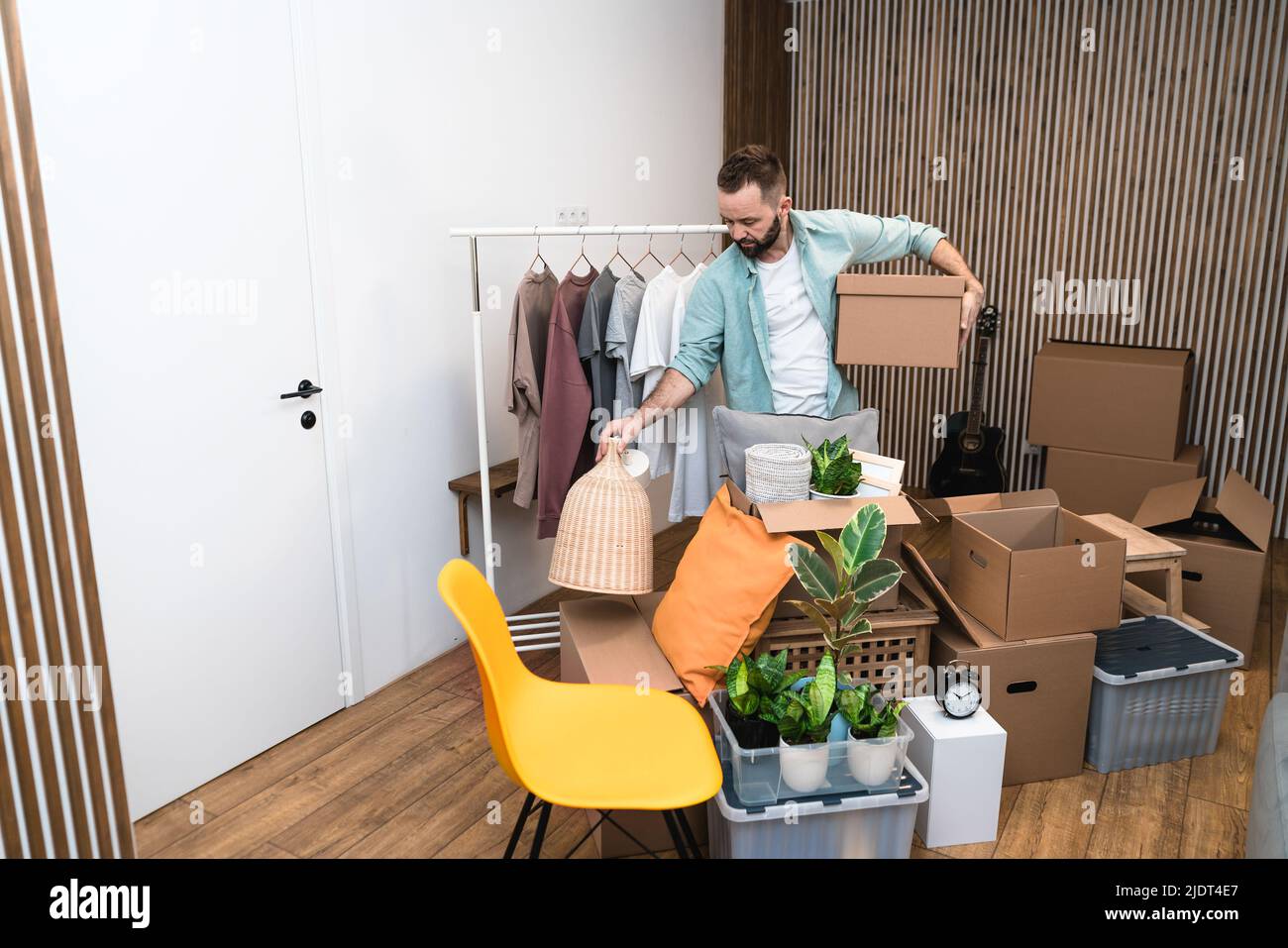 Hipster man with moving boxes in new modern apartment. Mature man ...