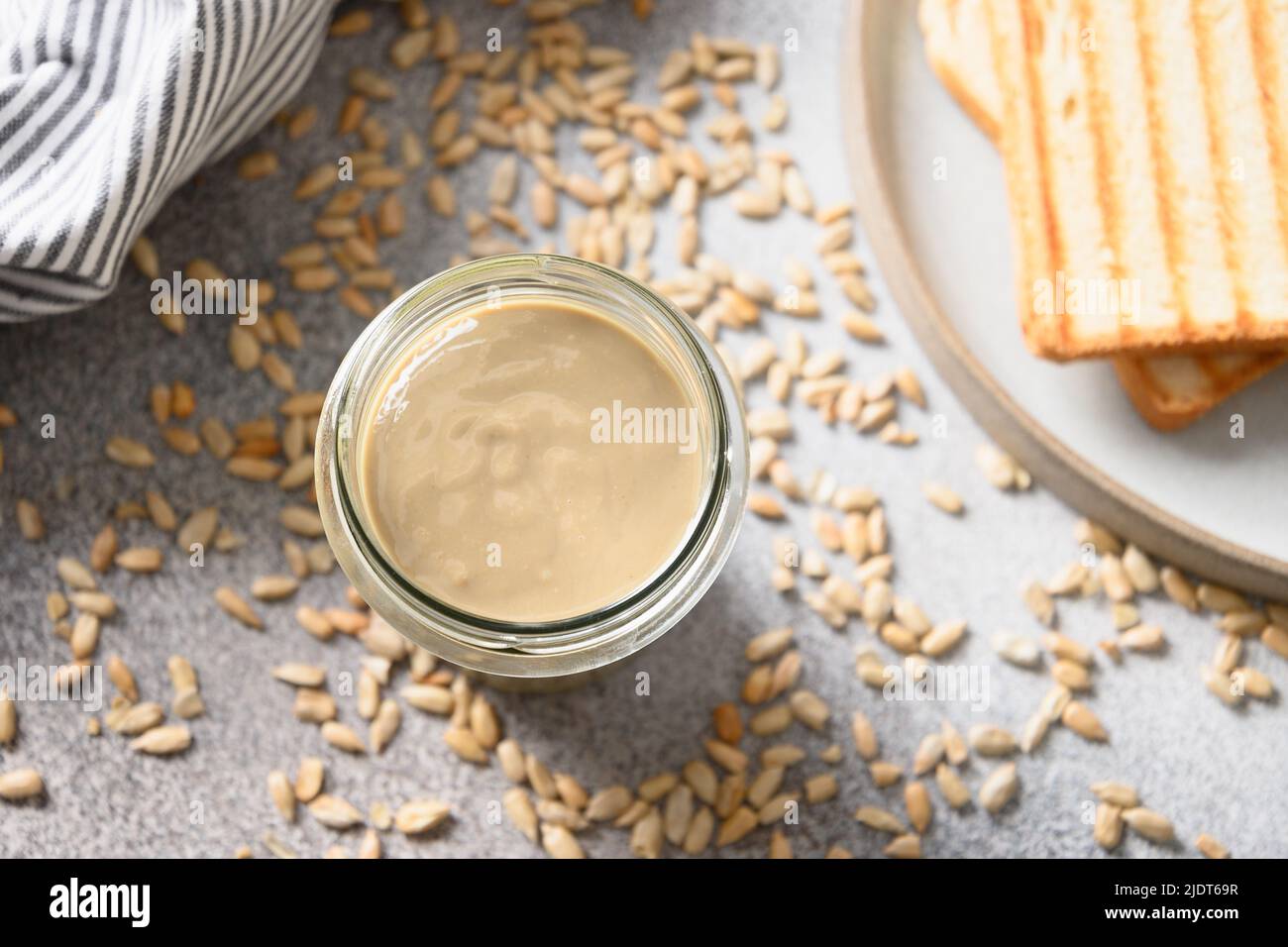 Sunflower seeds butter in glass jar. Nut free vegan spread Stock Photo