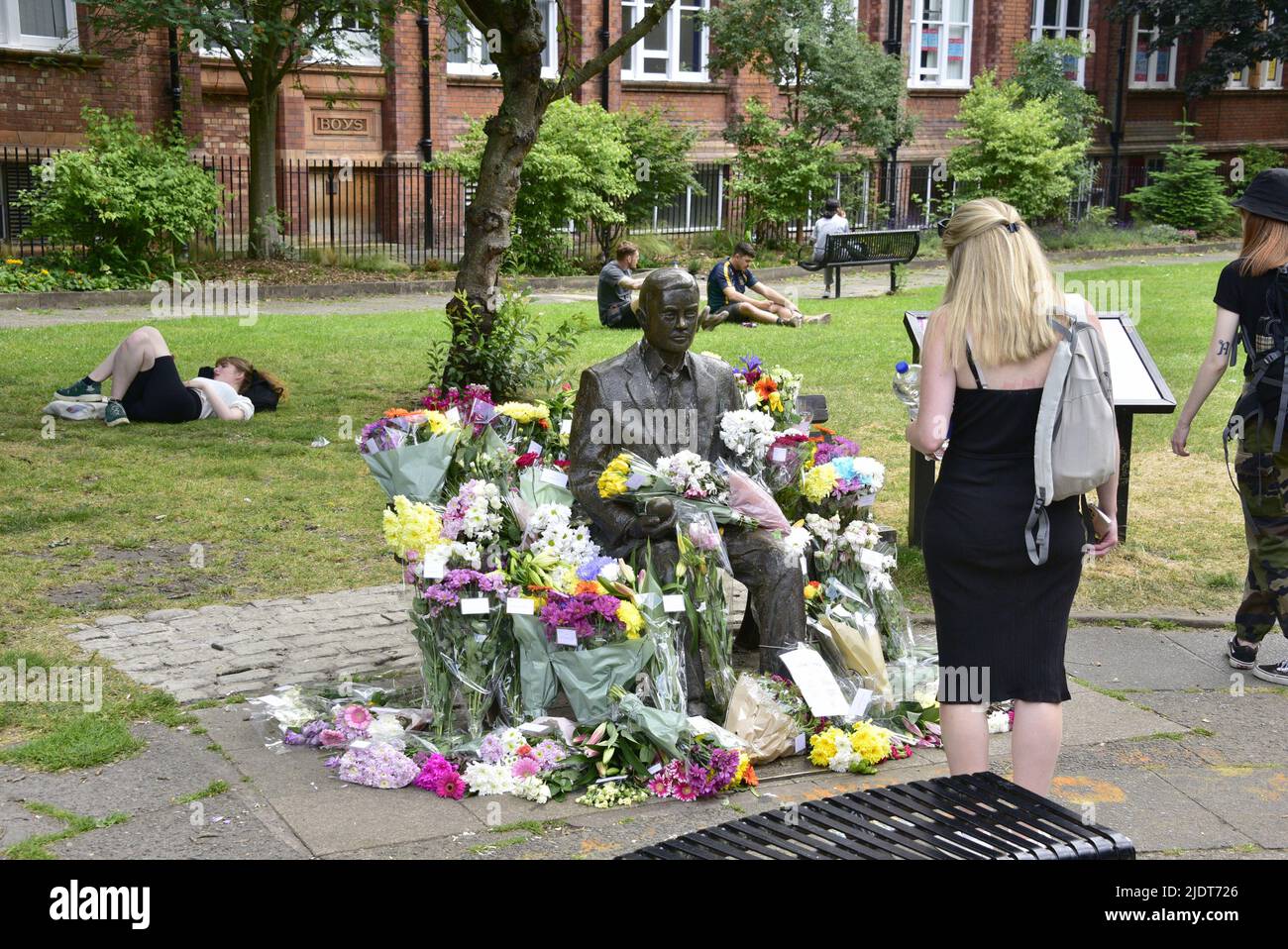 Manchester, UK. 23rd June, 2022. Bunches of flowers left at the Alan Turing statue to celebrate Turing's birthday on 23rd June at Sackville Gardens, central Manchester, England, UK. Turing  is considered to be the father of theoretical computer science and artificial intelligence, played a major role in the development of early computers at the University of Manchester and was a renowned World War II codebreaker. The charity 'eQuality Time' takes the lead in leaving flowers on this date. Credit: Terry Waller/Alamy Live News Stock Photo