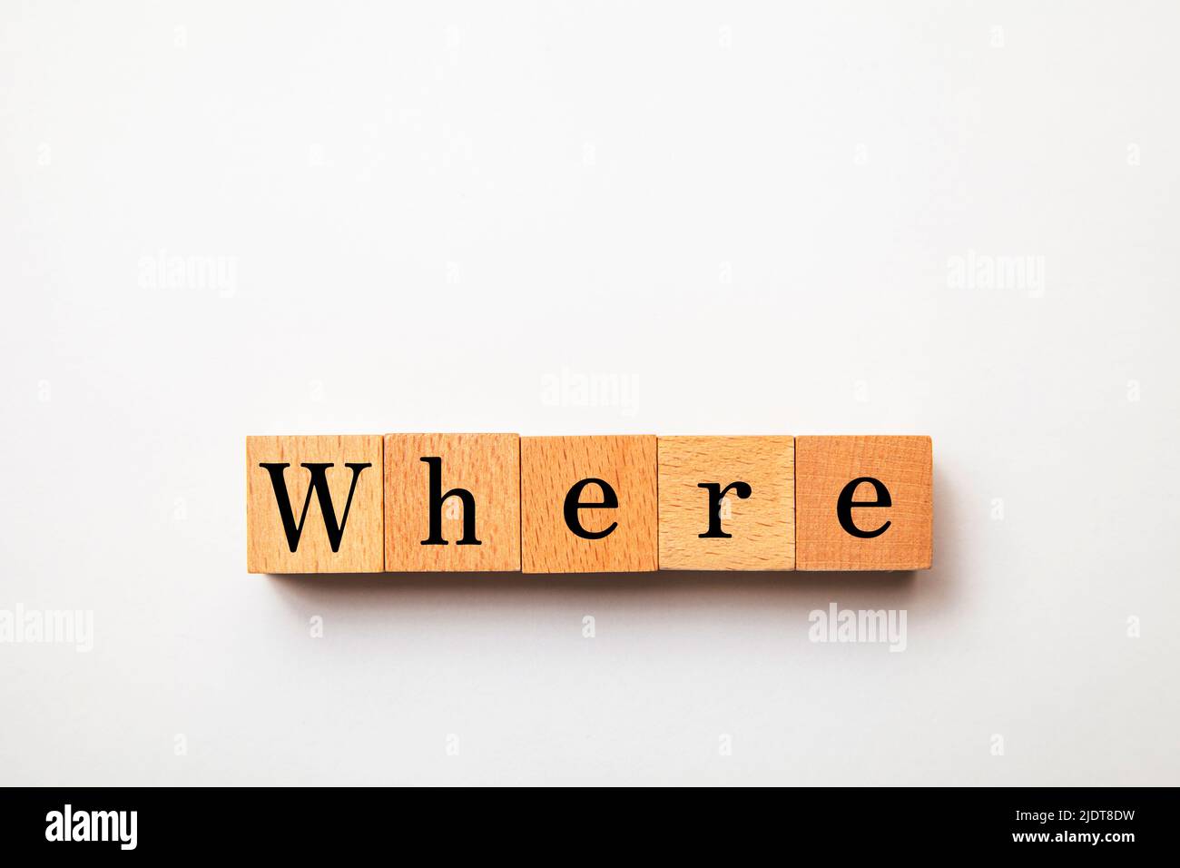 Where character. Where. Interrogative pronoun. Written on five wooden blocks. Black letters. White background. Stock Photo