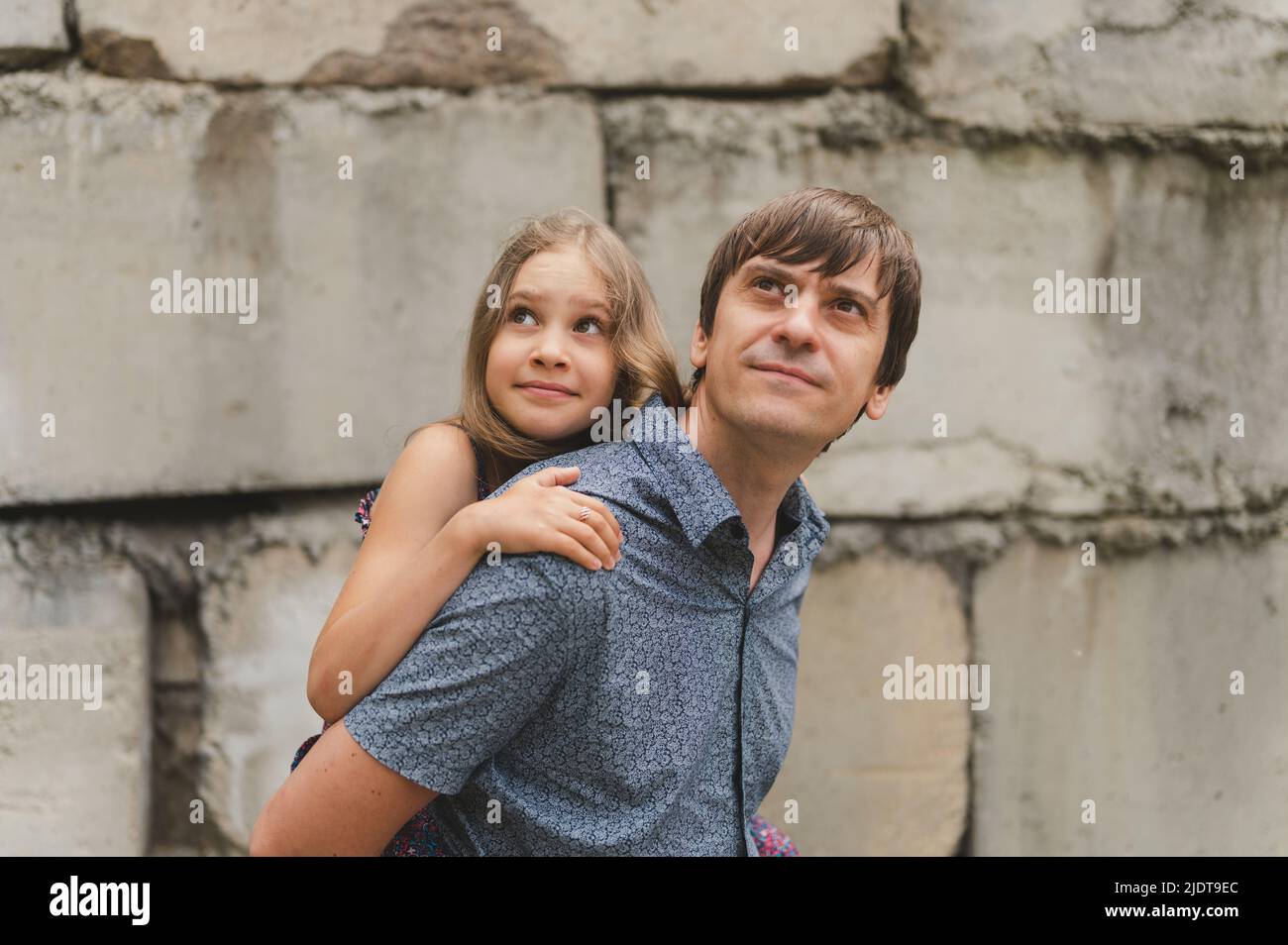 man dad having quality time with their kid daughter girl nine year old on his back. happy father playing with child. real life authentic day-to-day fa Stock Photo