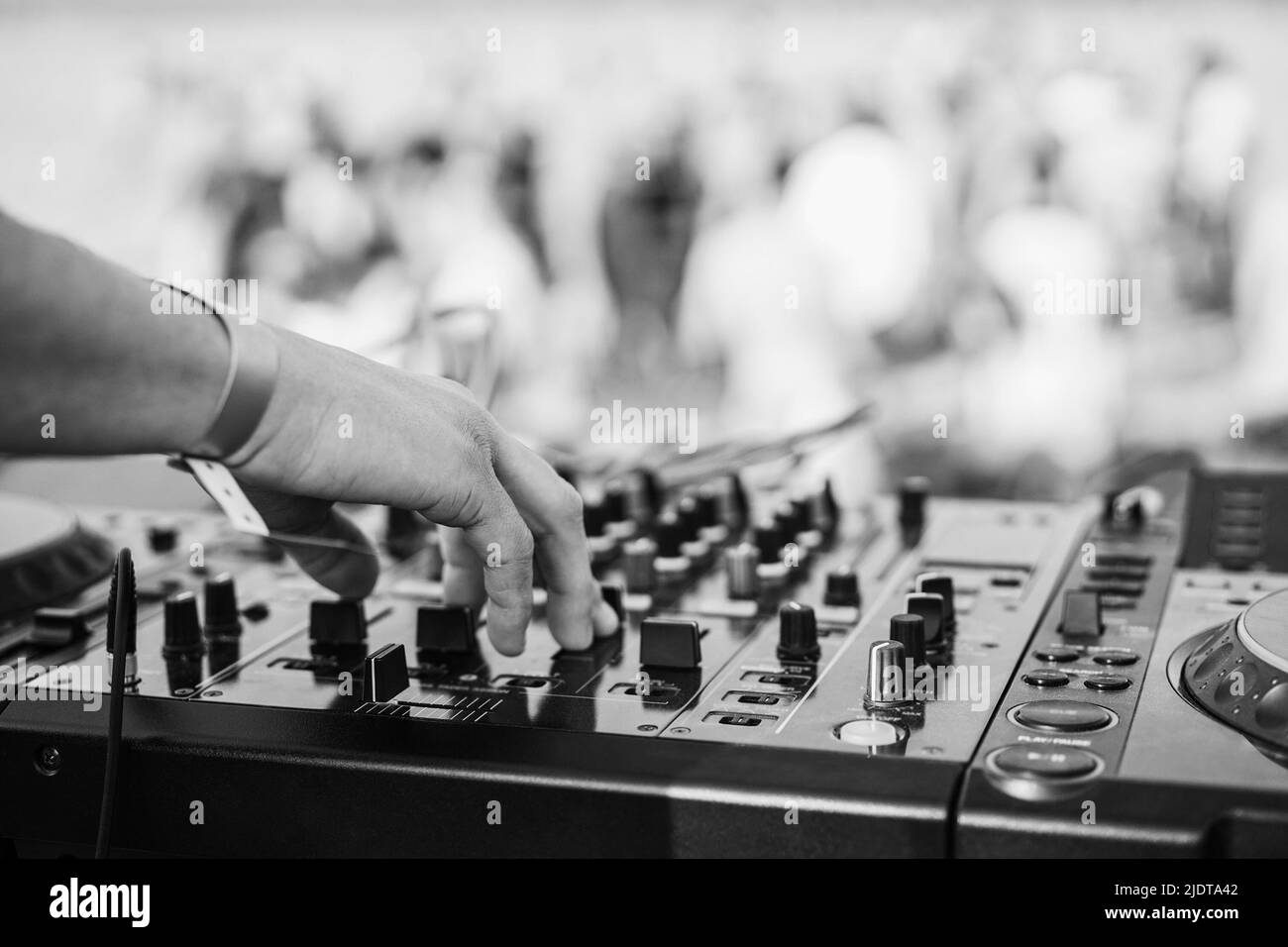 Dj mixing at beach party during summer vacation outdoor - Focus on hand - Black and white editing Stock Photo