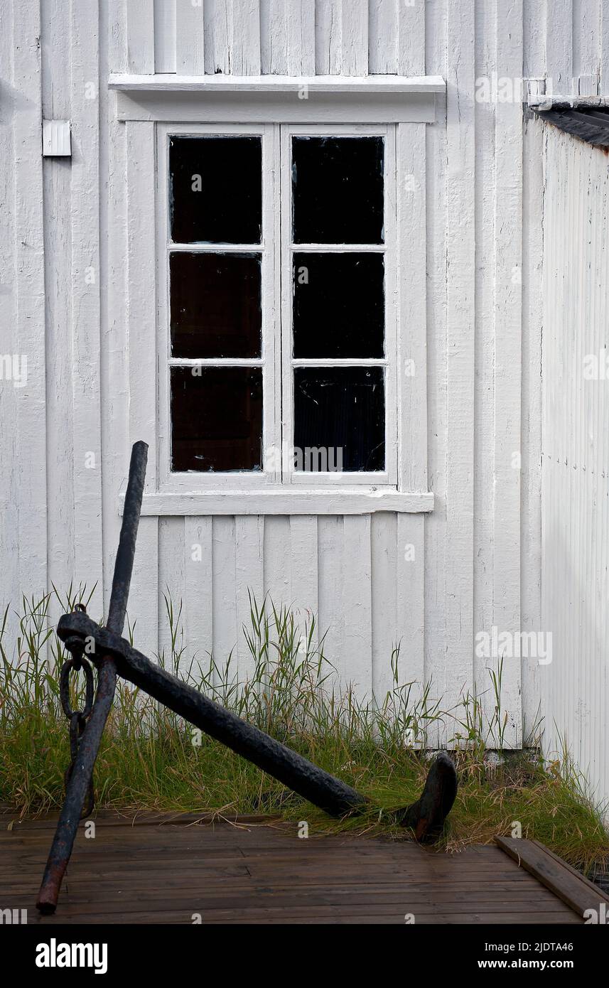 Old house and anchor at the small settlement of Töa at Tindsöya, Vestraalen, Norway. Stock Photo