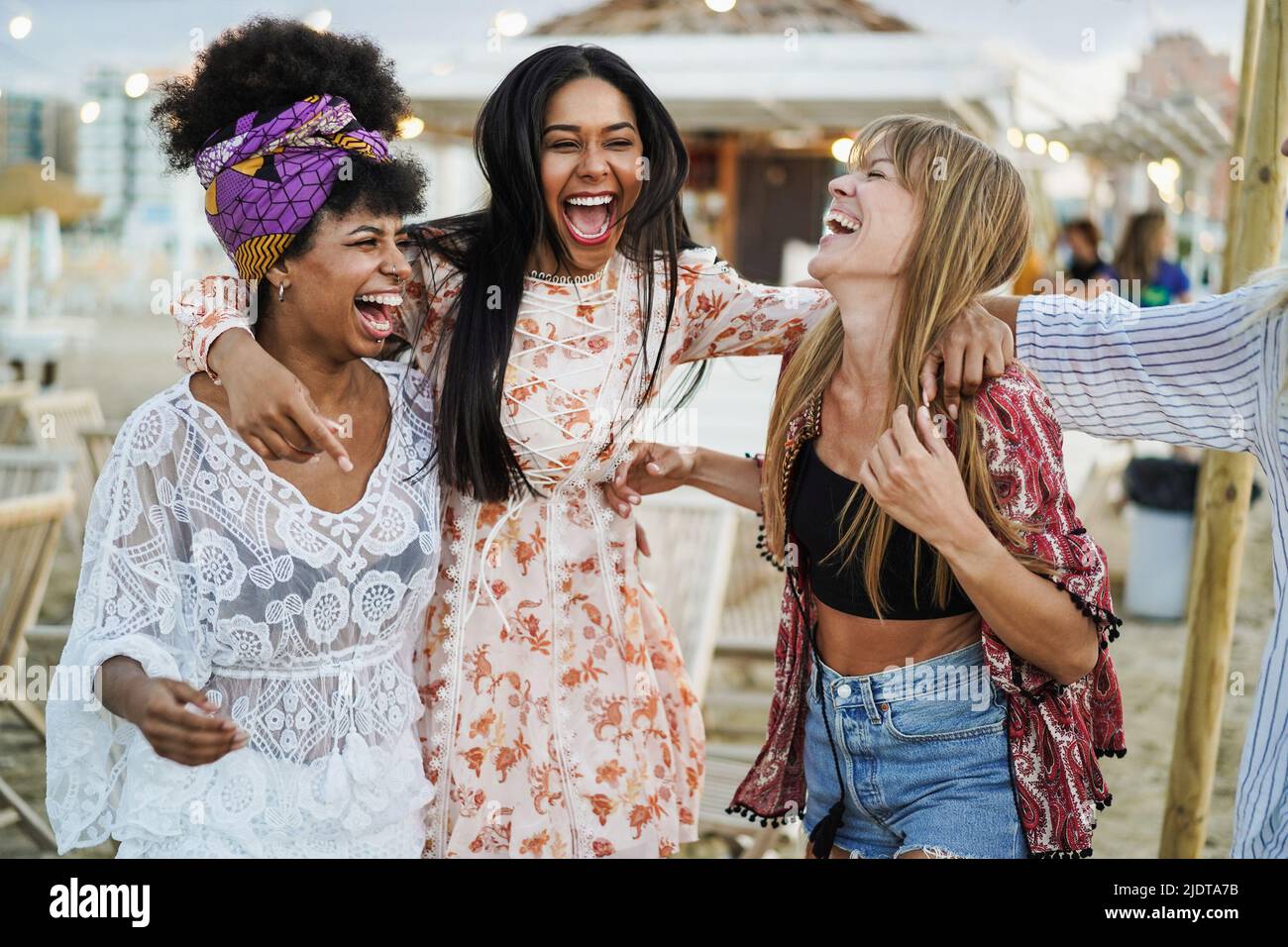 Multiracial happy friends having fun outdoor at beach party - Soft focus on right girl pants Stock Photo