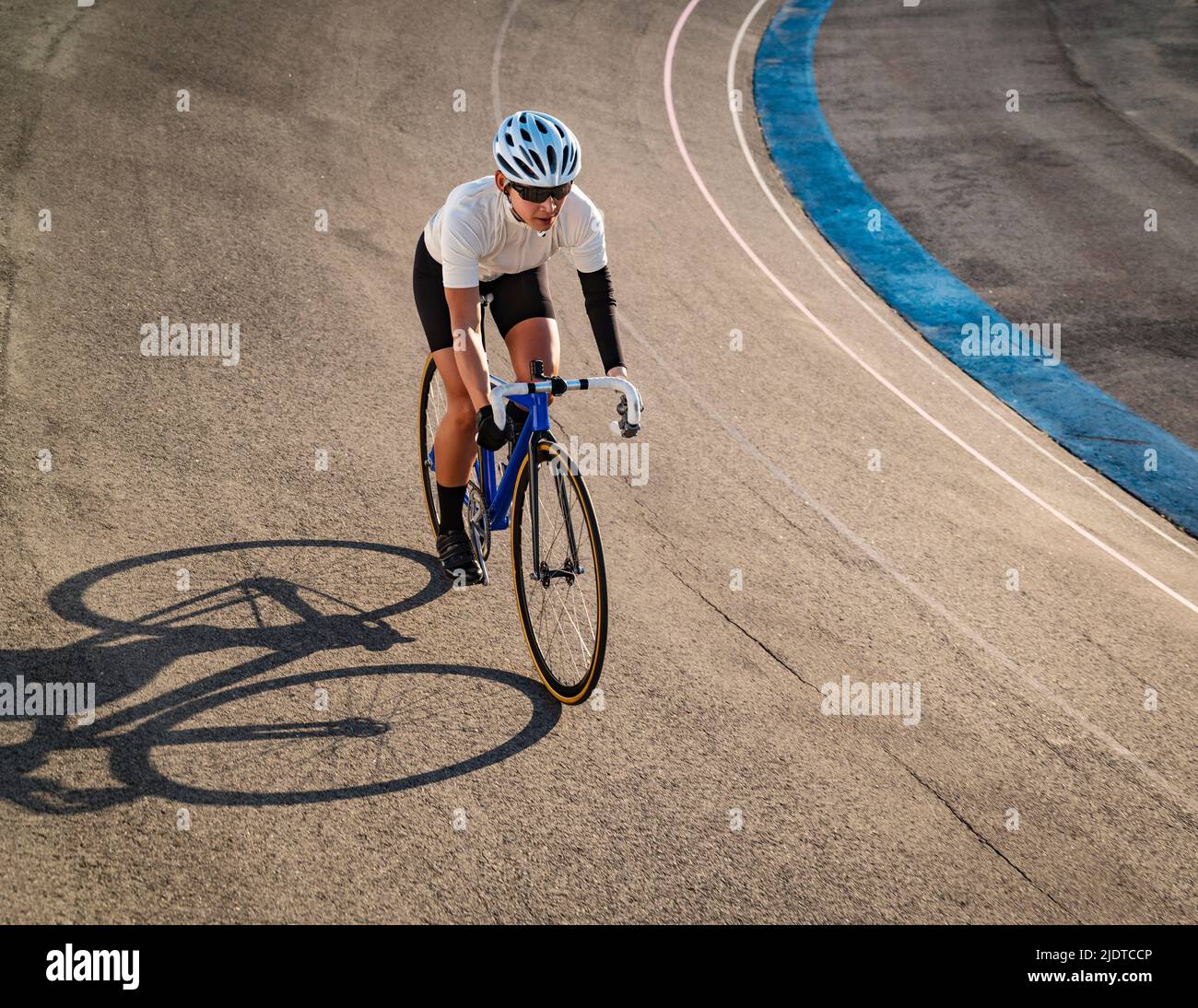 Athletic woman with amputated hand cycling on track Stock Photo