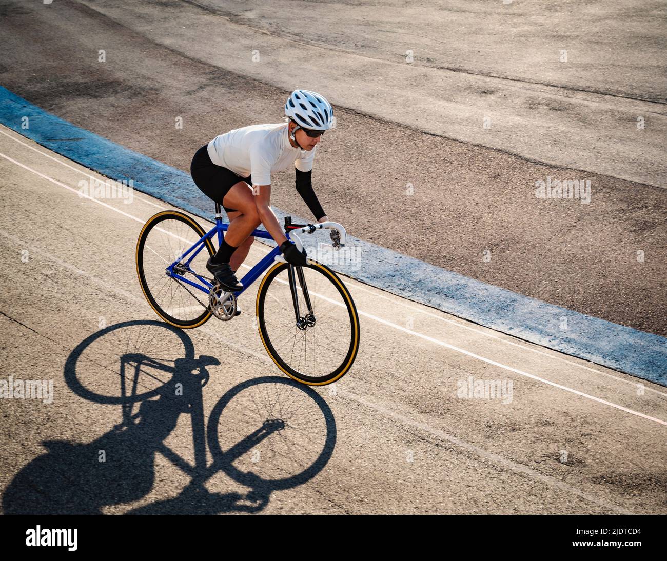 Athletic woman with amputated hand cycling on track Stock Photo