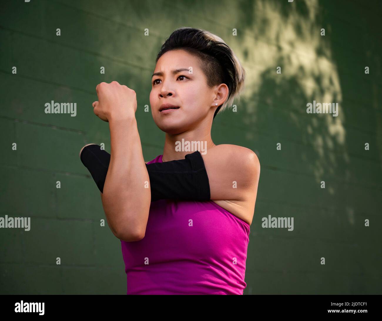 Athletic woman with amputated hand stretching arm Stock Photo