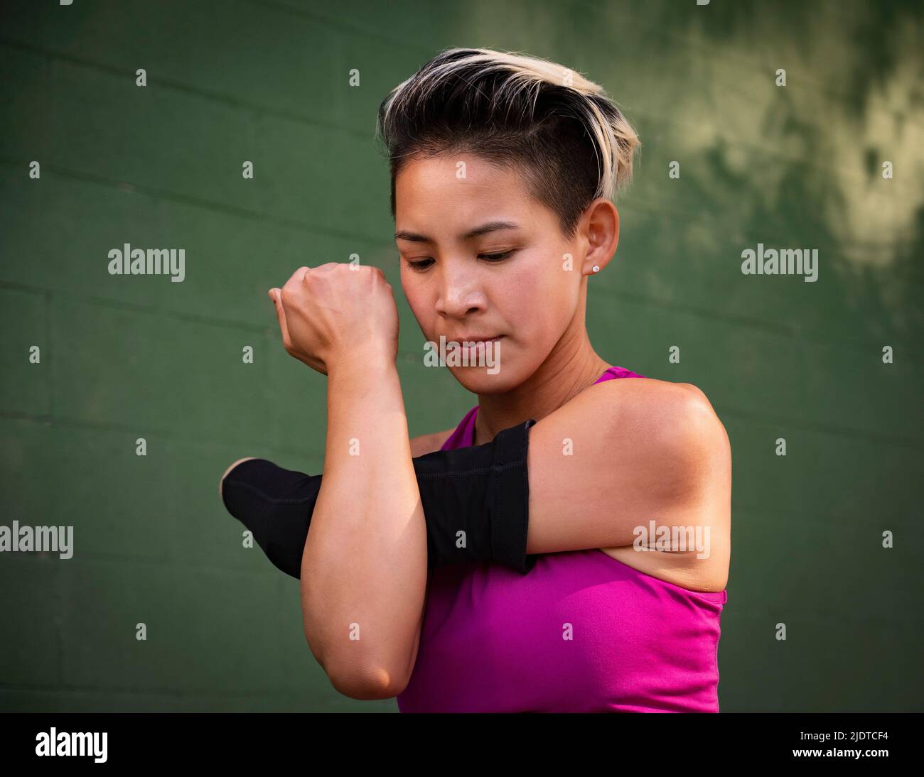 Athletic woman with amputated hand stretching arm Stock Photo