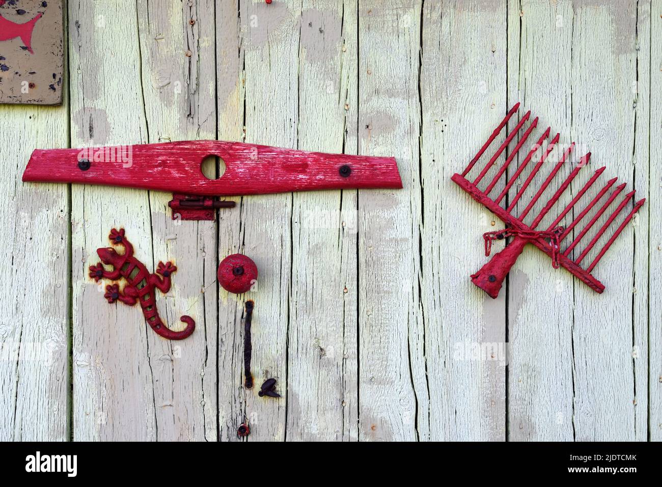 Old Shed Door Decorated with Metal Junk including Toy Metal Lizard and old Rake Head on Boat Shed on Bregancon Beach Var Provence France Stock Photo