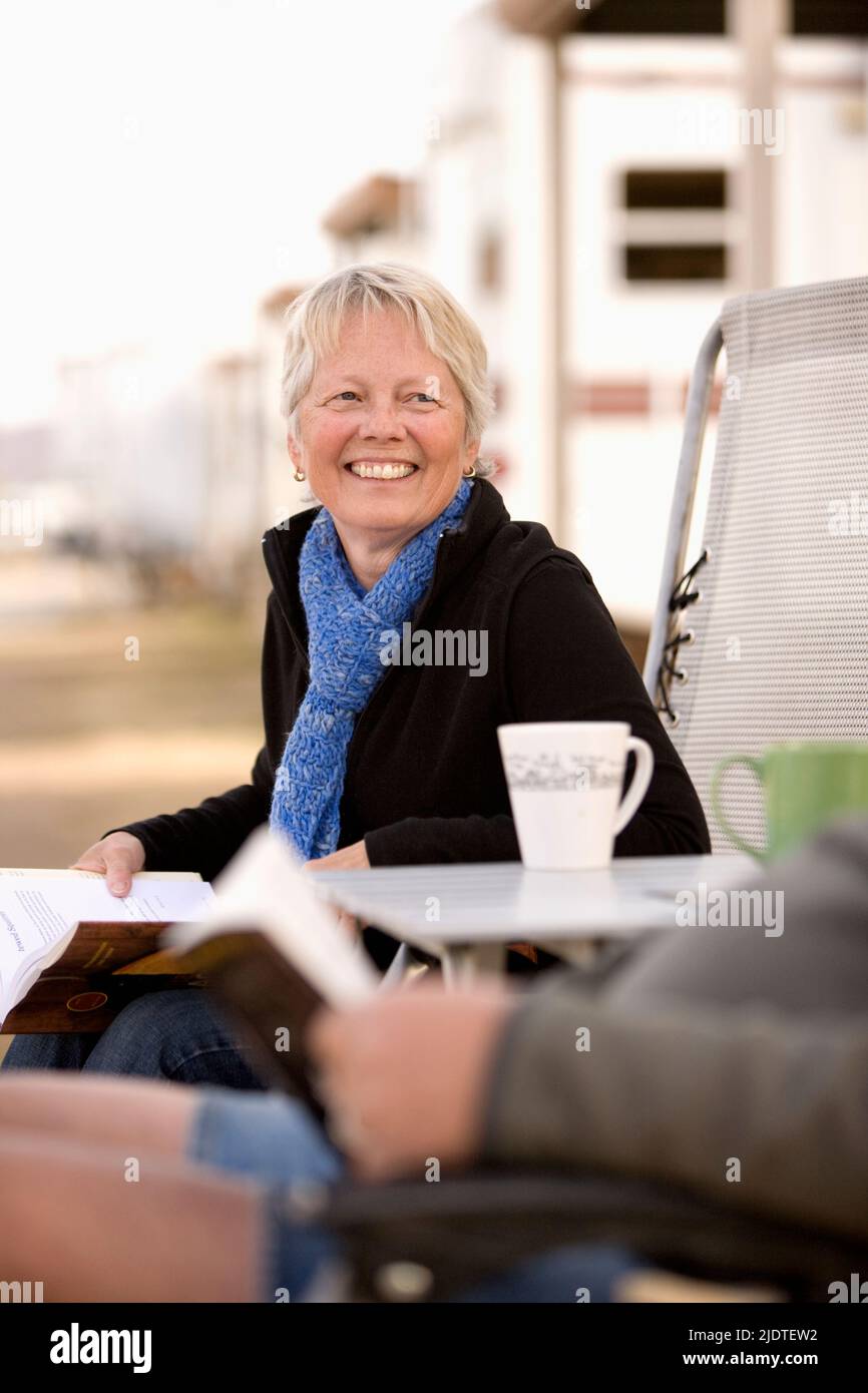 Mature Woman from Idaho sitting eading in RV park for the winter in Arizona Stock Photo