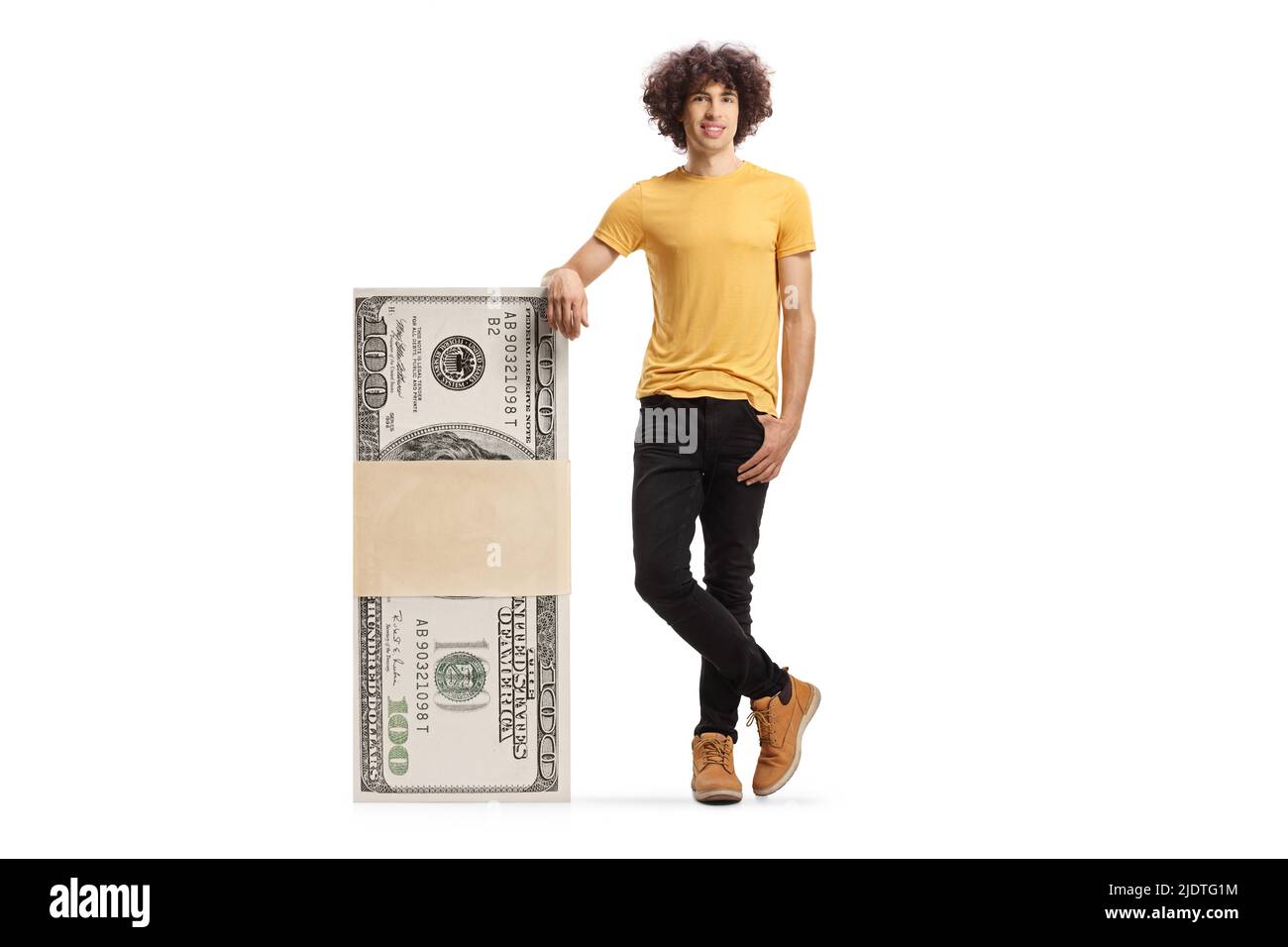 Young man leaning on a stack of us dollar banknotes isolated on white background Stock Photo