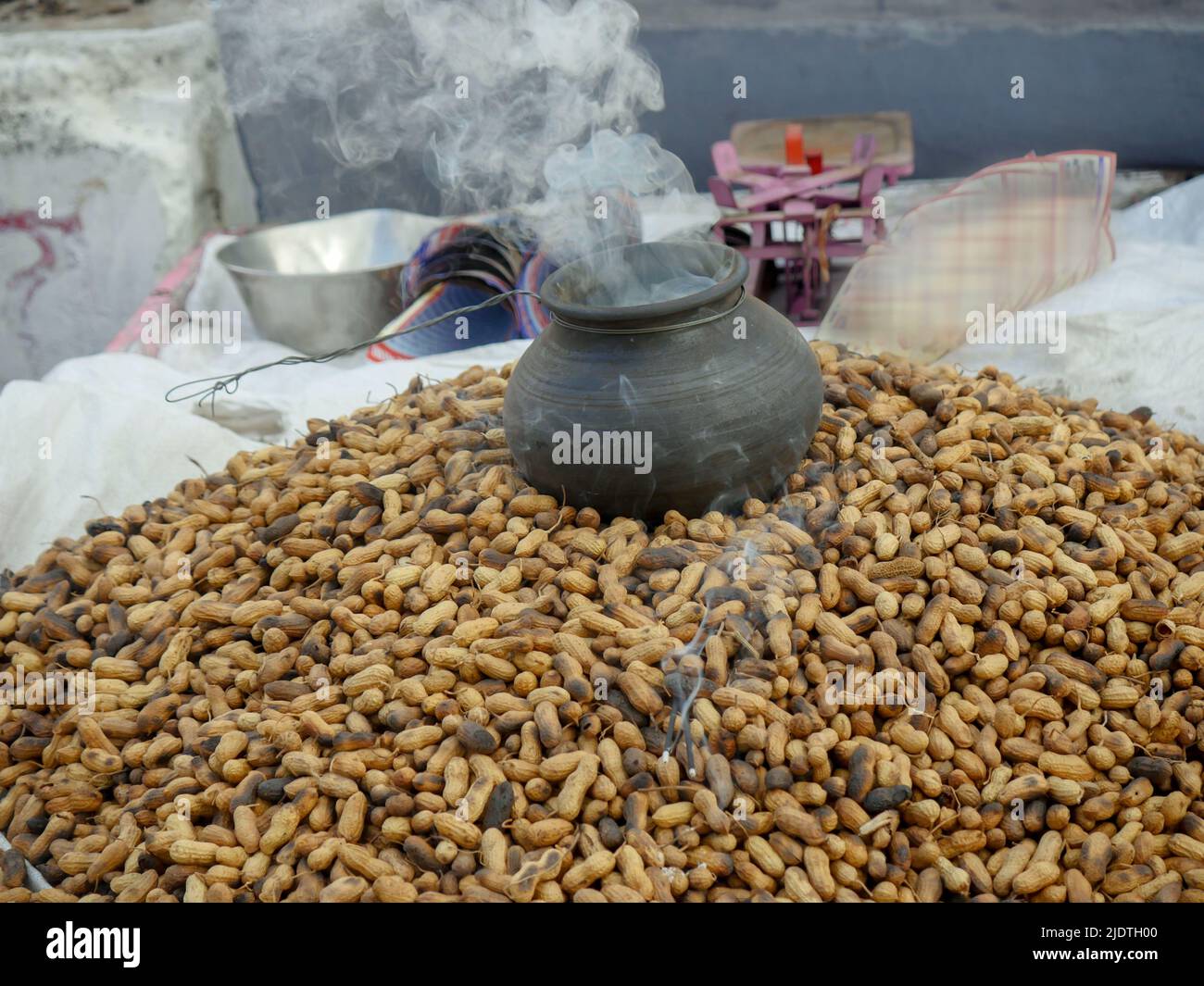 Heap of roasting raw peanuts, Smoke coming out of pot with peanuts