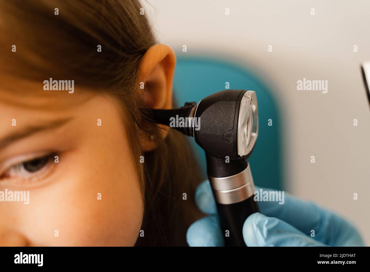 Closeup examination of childs ear with otoscope. Otoscopy. Visit to