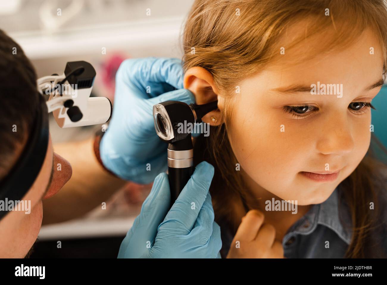 Closeup examination of childs ear with otoscope. Otoscopy. Visit to