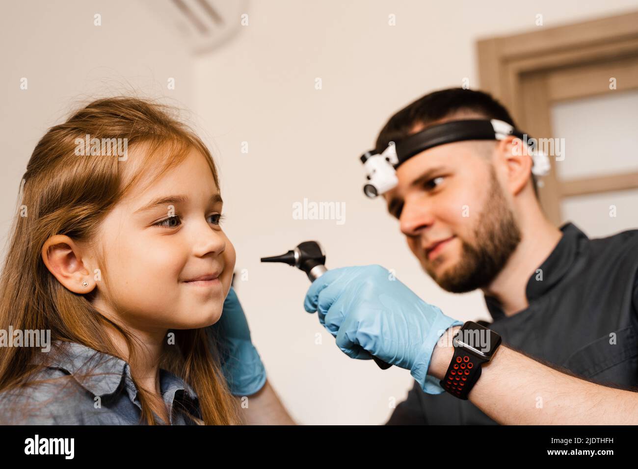 ENT doctor with otoscope. Otoscopy. Pediatrician otolaryngologist looks