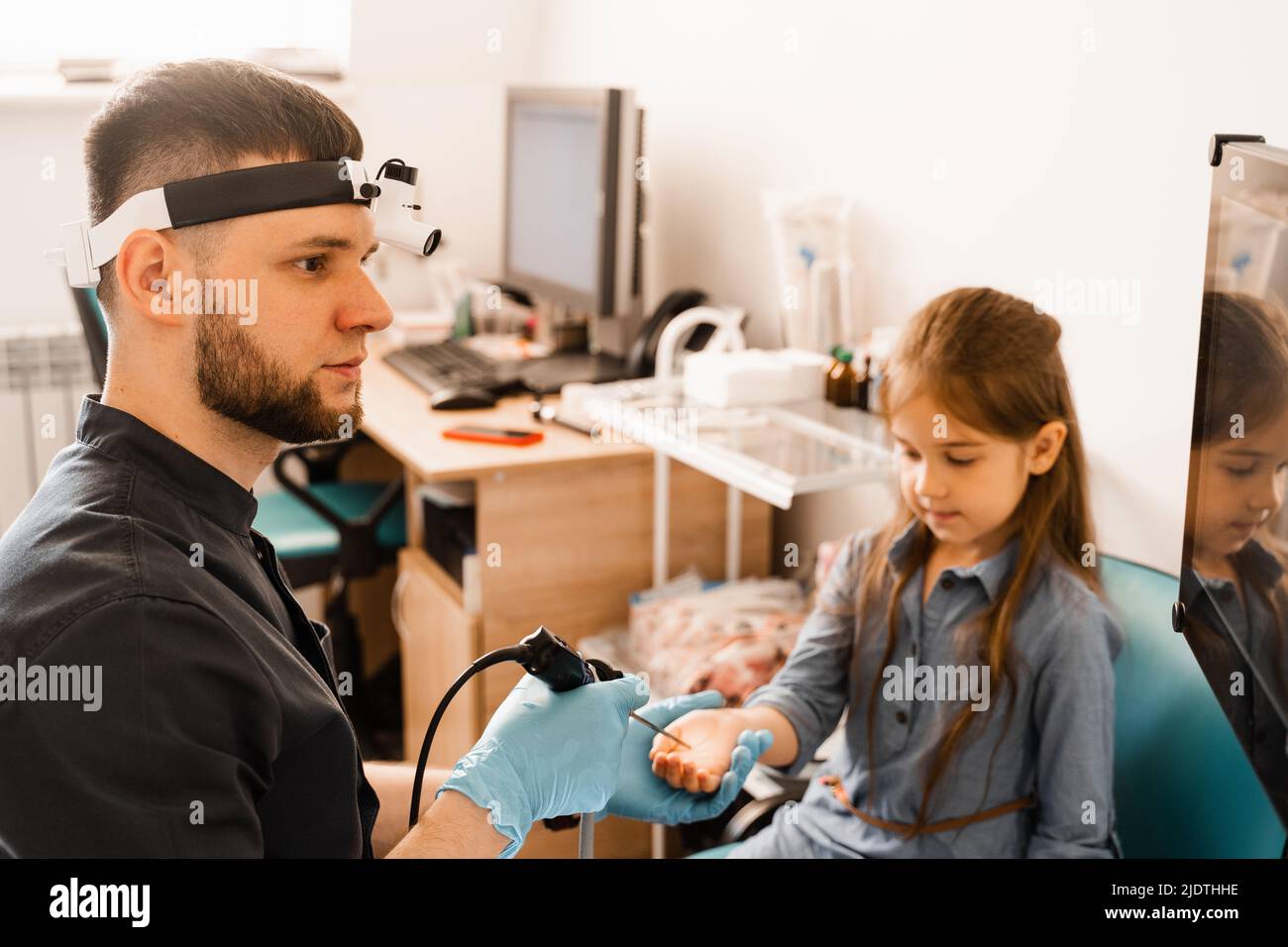 Ears endoscopy of child. Otoscopy procedure with otoscope. ENT doctor
