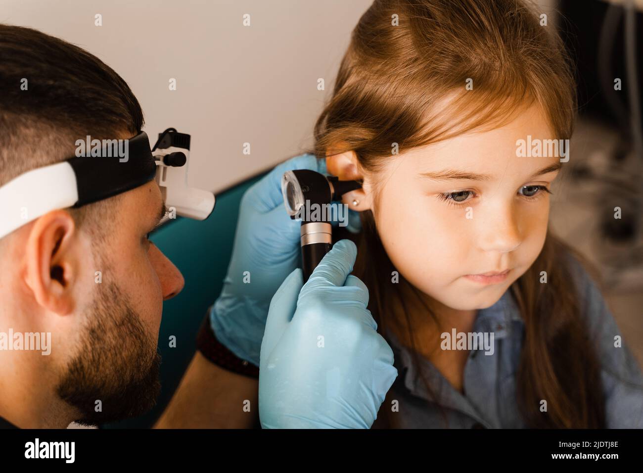 Closeup examination of childs ear with otoscope. Otoscopy. Visit to