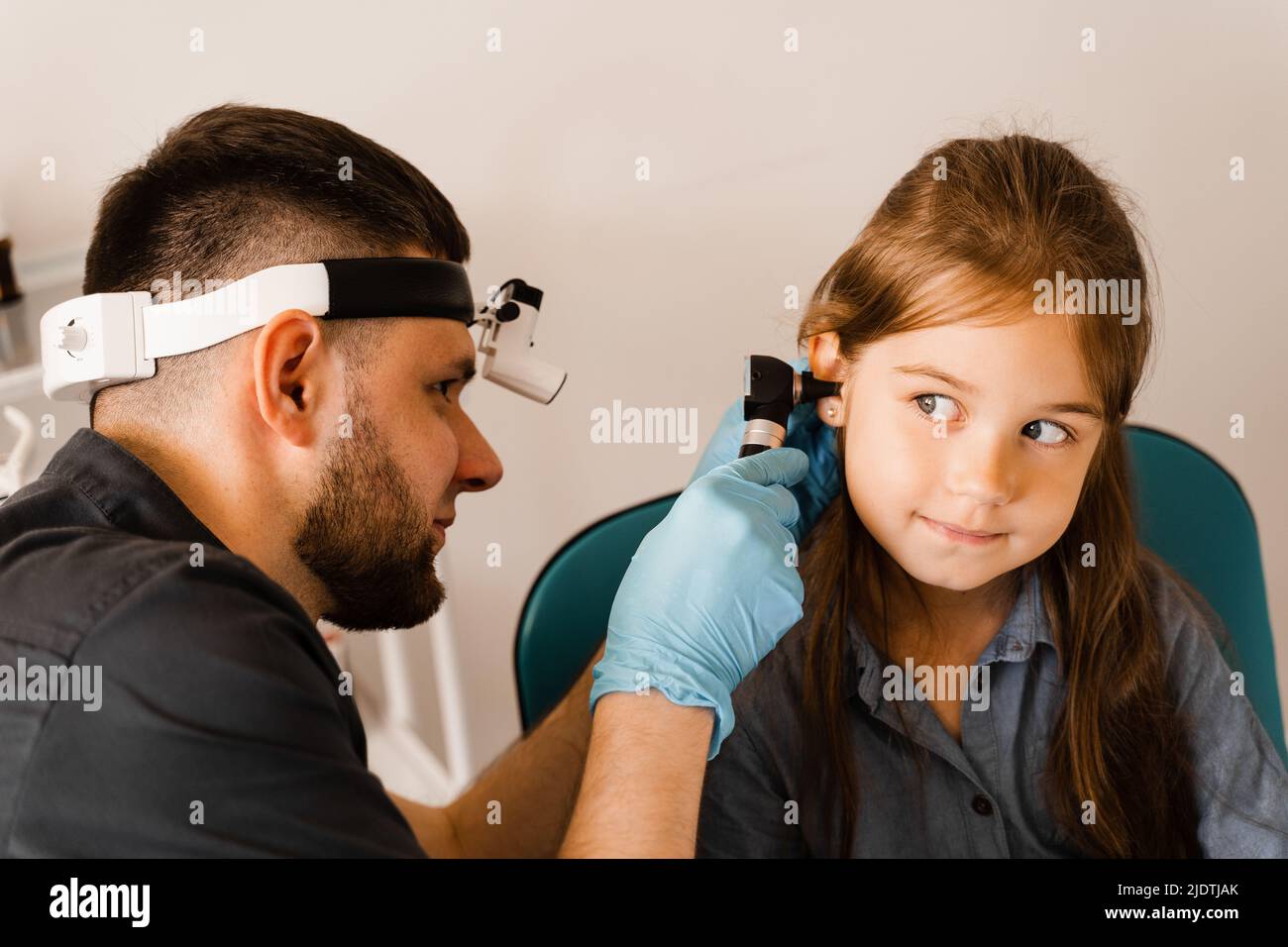 ENT doctor with otoscope. Otoscopy. Pediatrician otolaryngologist looks