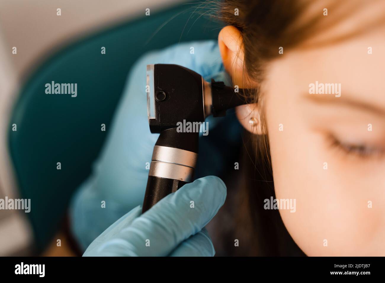 Closeup examination of childs ear with otoscope. Otoscopy. Visit to