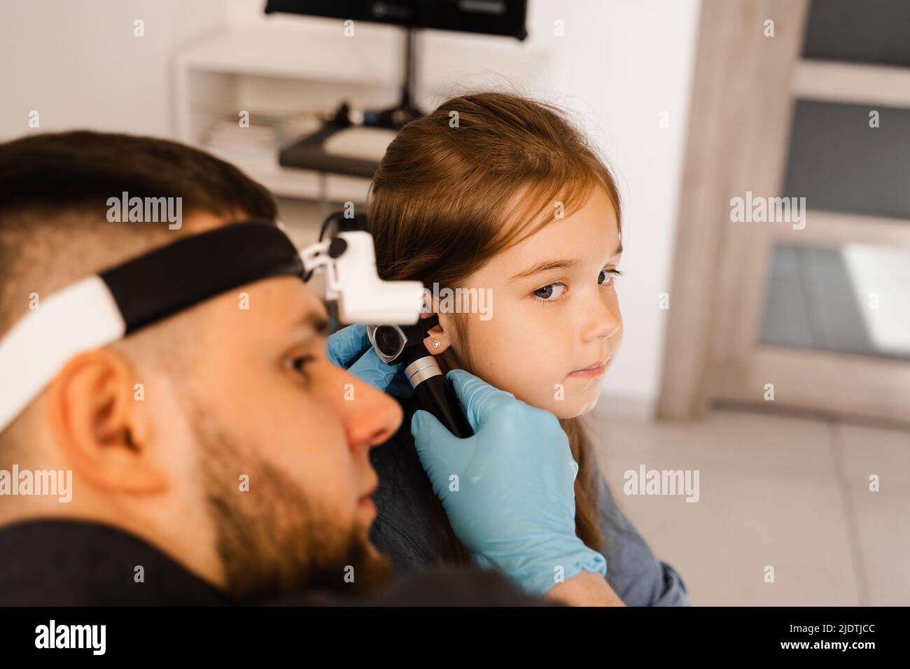 ENT doctor with otoscope. Otoscopy. Pediatrician otolaryngologist looks