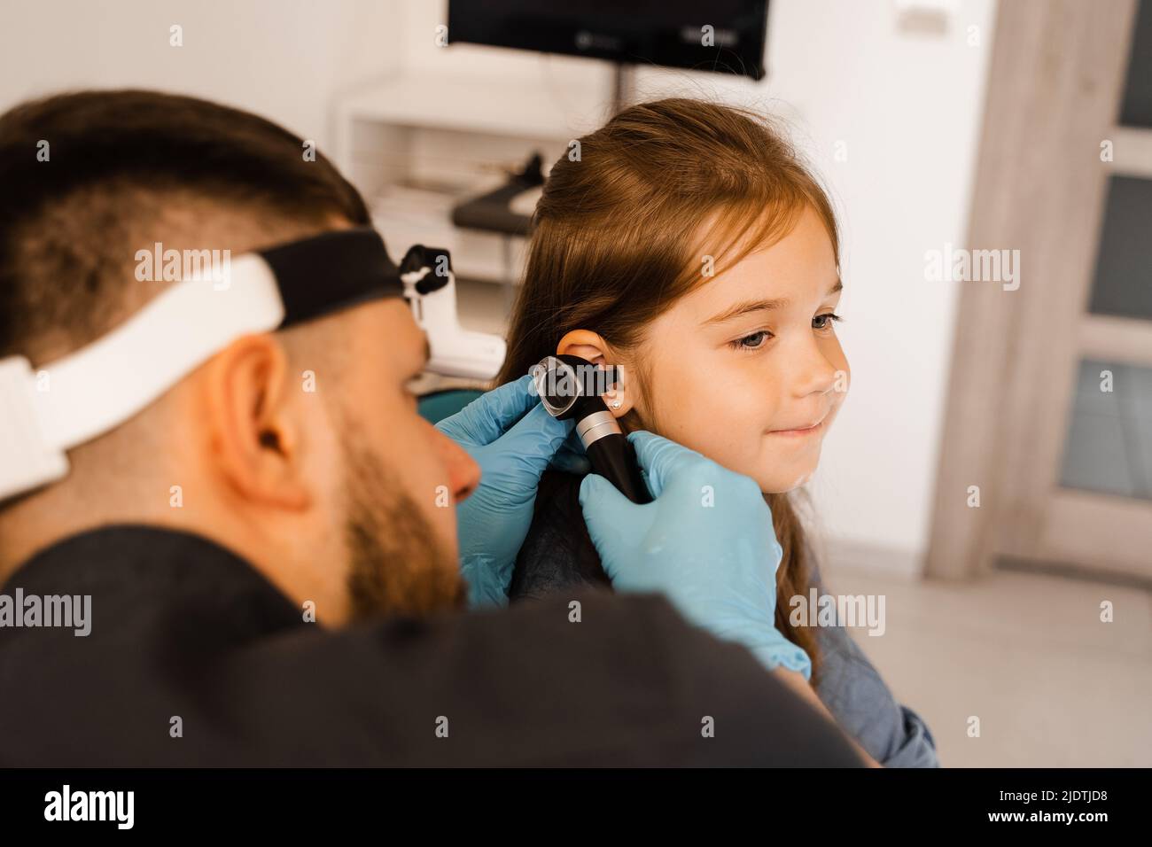 ENT doctor with otoscope. Otoscopy. Pediatrician otolaryngologist looks