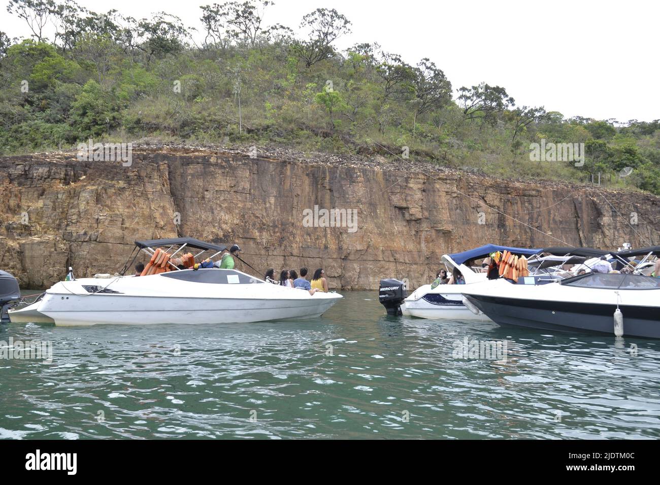 Tourists on a speedboat ride, in the background rocky walls and above trees and green vegetation, with several boats anchored, Brazil, South America, Stock Photo