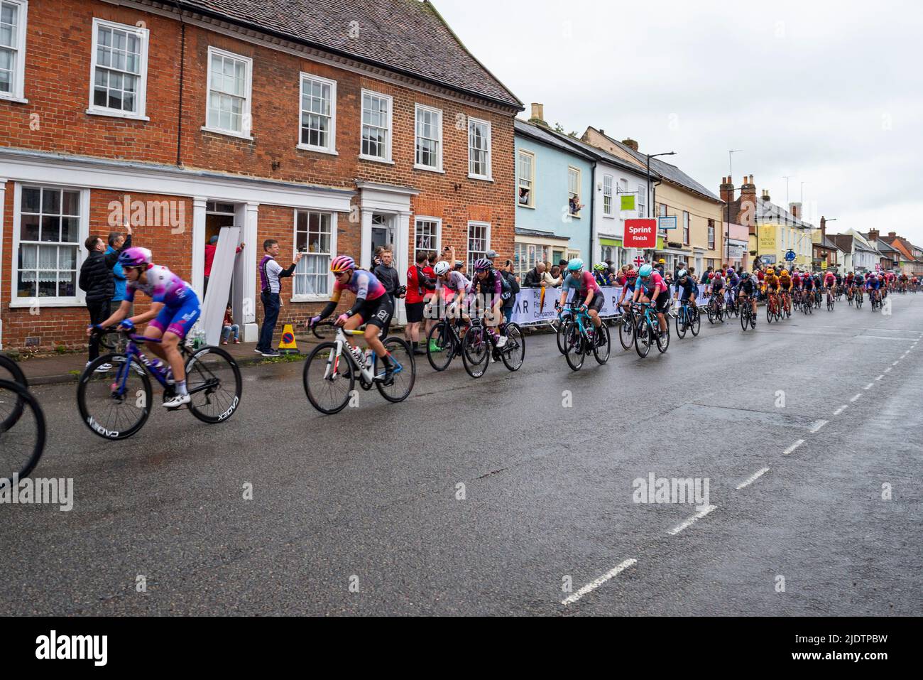 UCI Women's Tour international cycle race passing through the High Street of the market town of Hadleigh in Suffolk, UK. Stock Photo