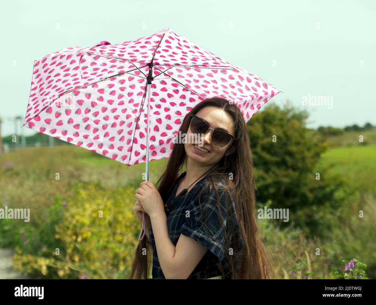 Young Women posing with an Umbrella, whilst out on a walk in the Kent Country Side, Stock Photo