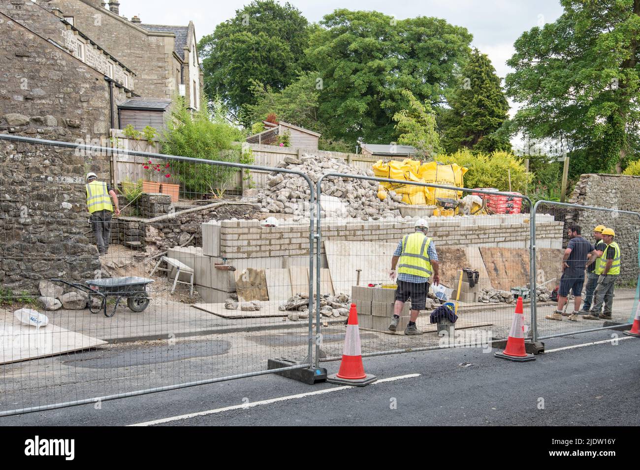 The team crack on with the stonework in front of the blockwork retaining wall. Kayley Hill, Long Preston wall repair proceeding at pace,23/6/22. Stock Photo