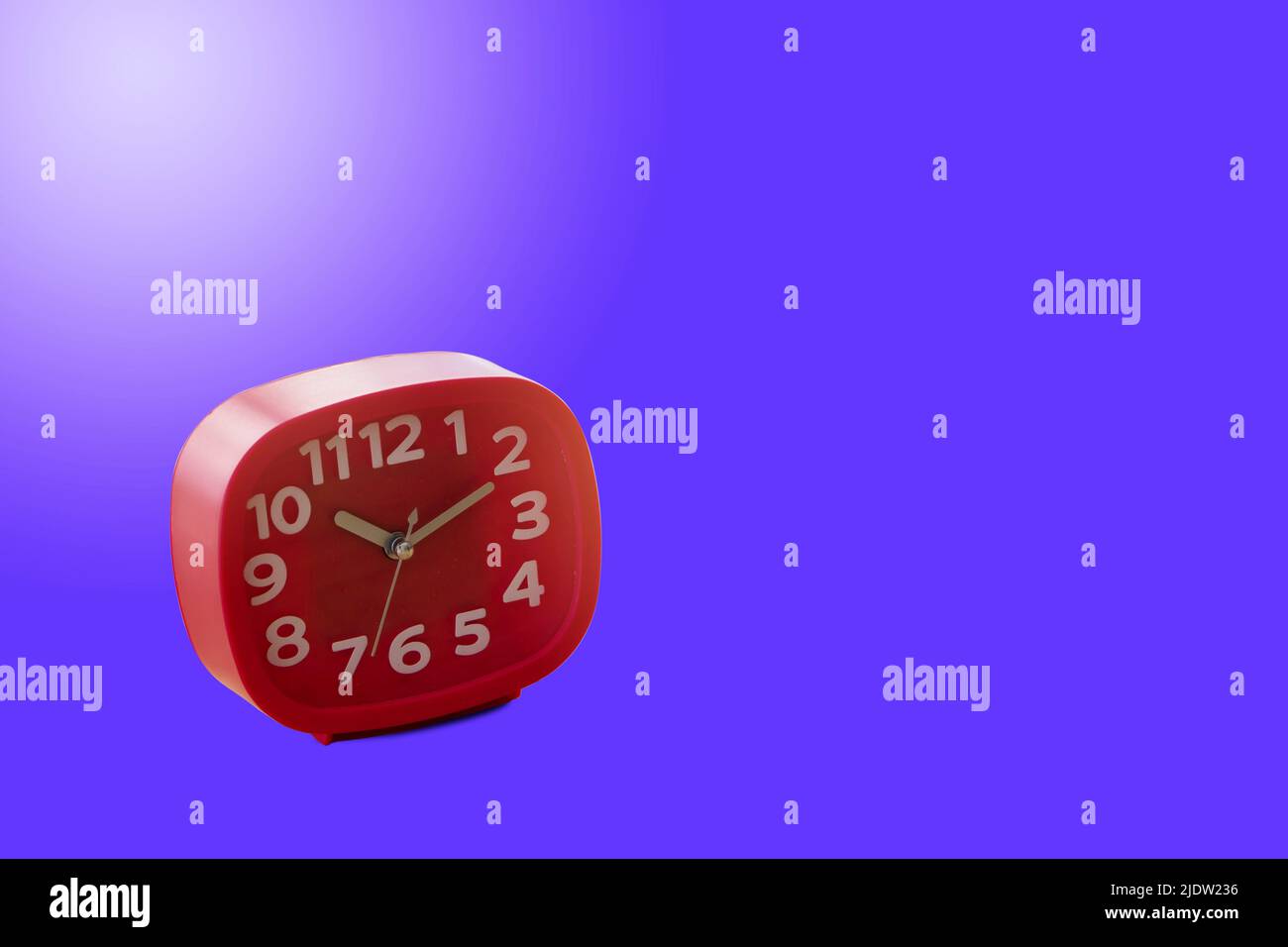 Red alarm clock isolated on blue background. Stock Photo