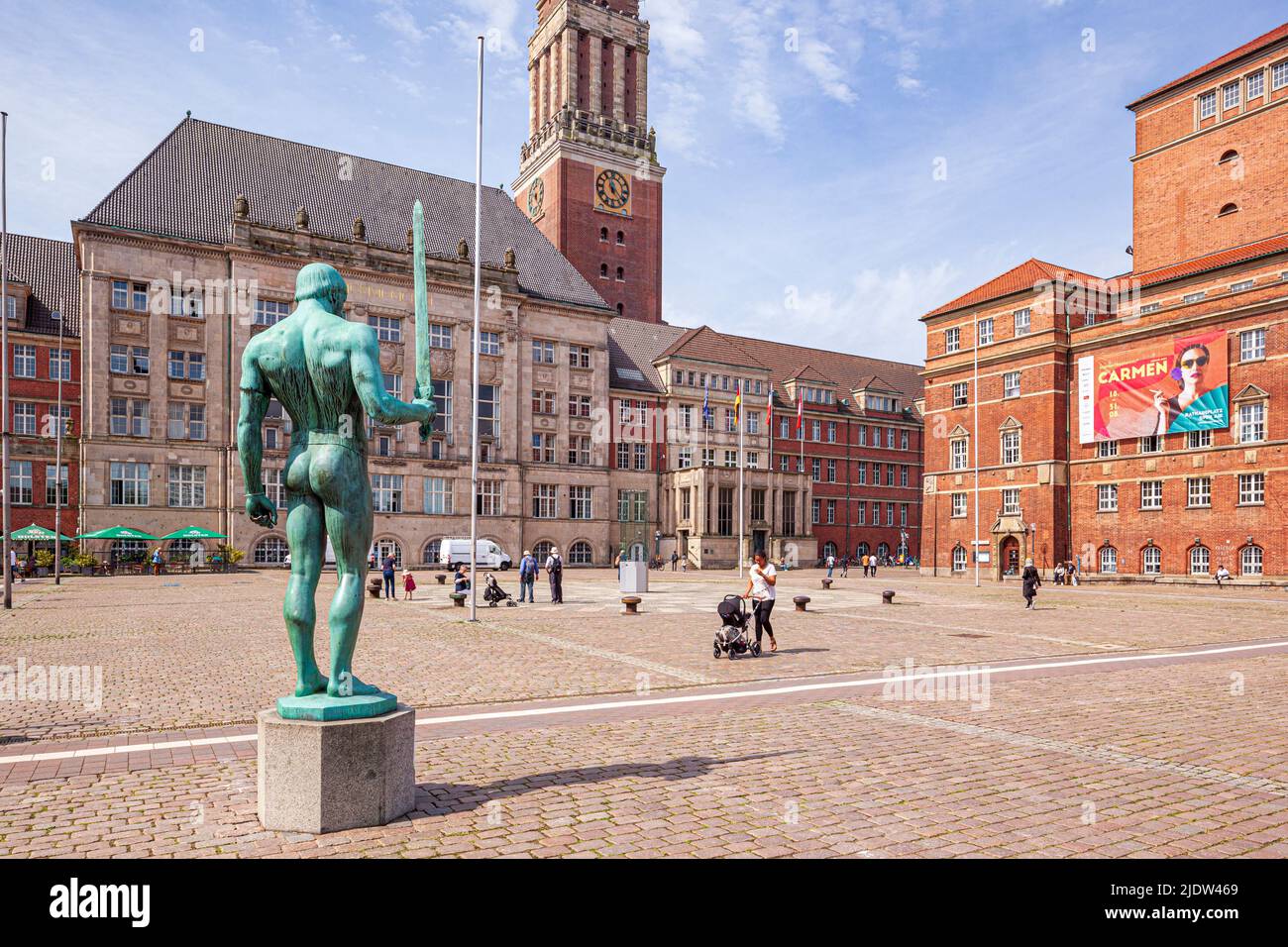 The statue of the Sword Bearer (Schwertträger) in Kieler Rathausplatz city square with the Town Hall (Landeshauptstadt) and Kiel Opera House Stock Photo