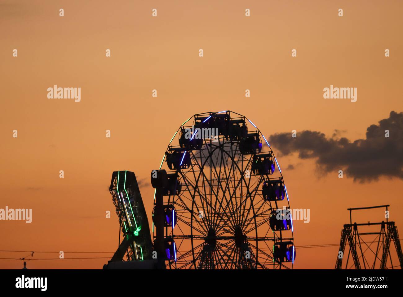 Ferris wheel in evening time with orange environment. Stock Photo