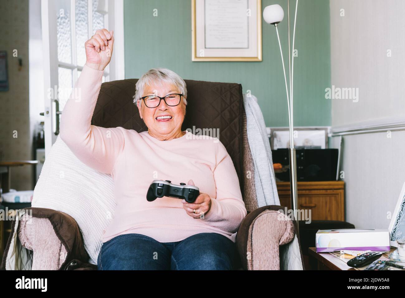 Emotional senior, mature woman looking at tv screen and using wireless