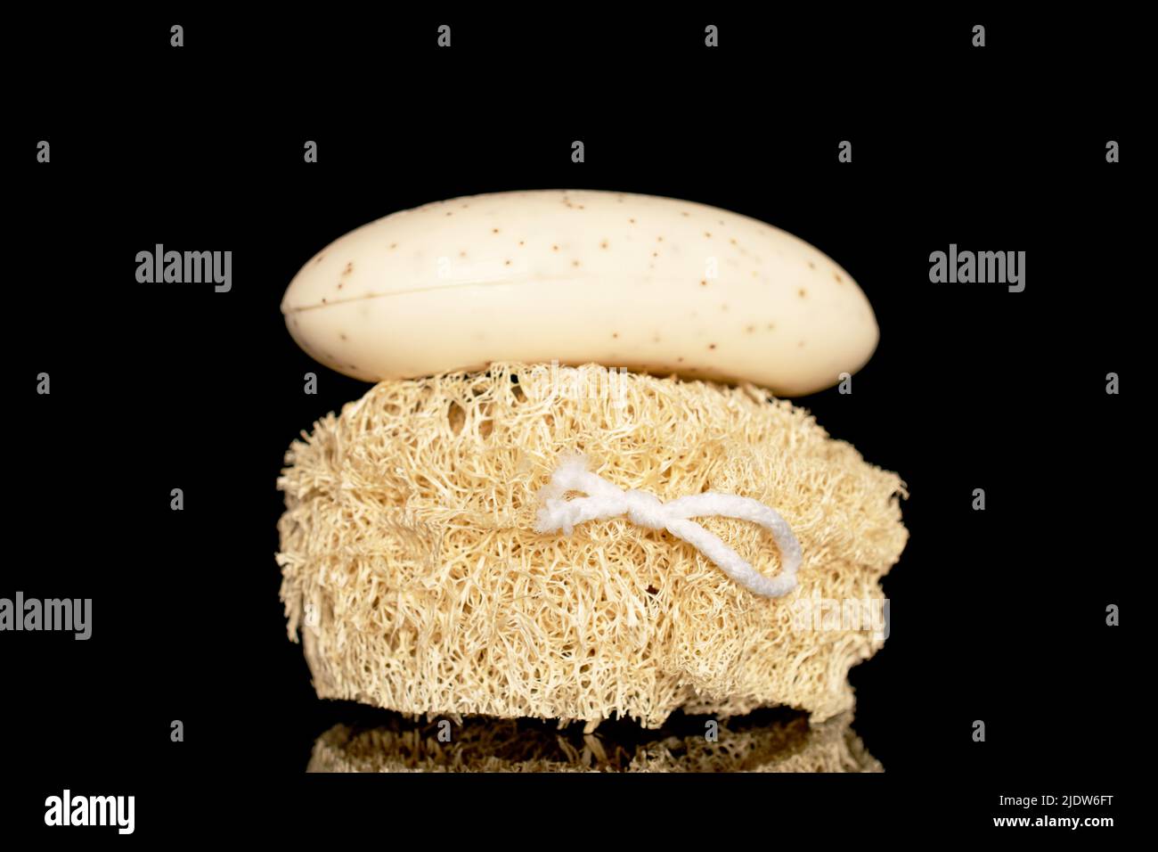 One loofah shower sponge and one bar of soap, close-up, isolated on a black background. Stock Photo