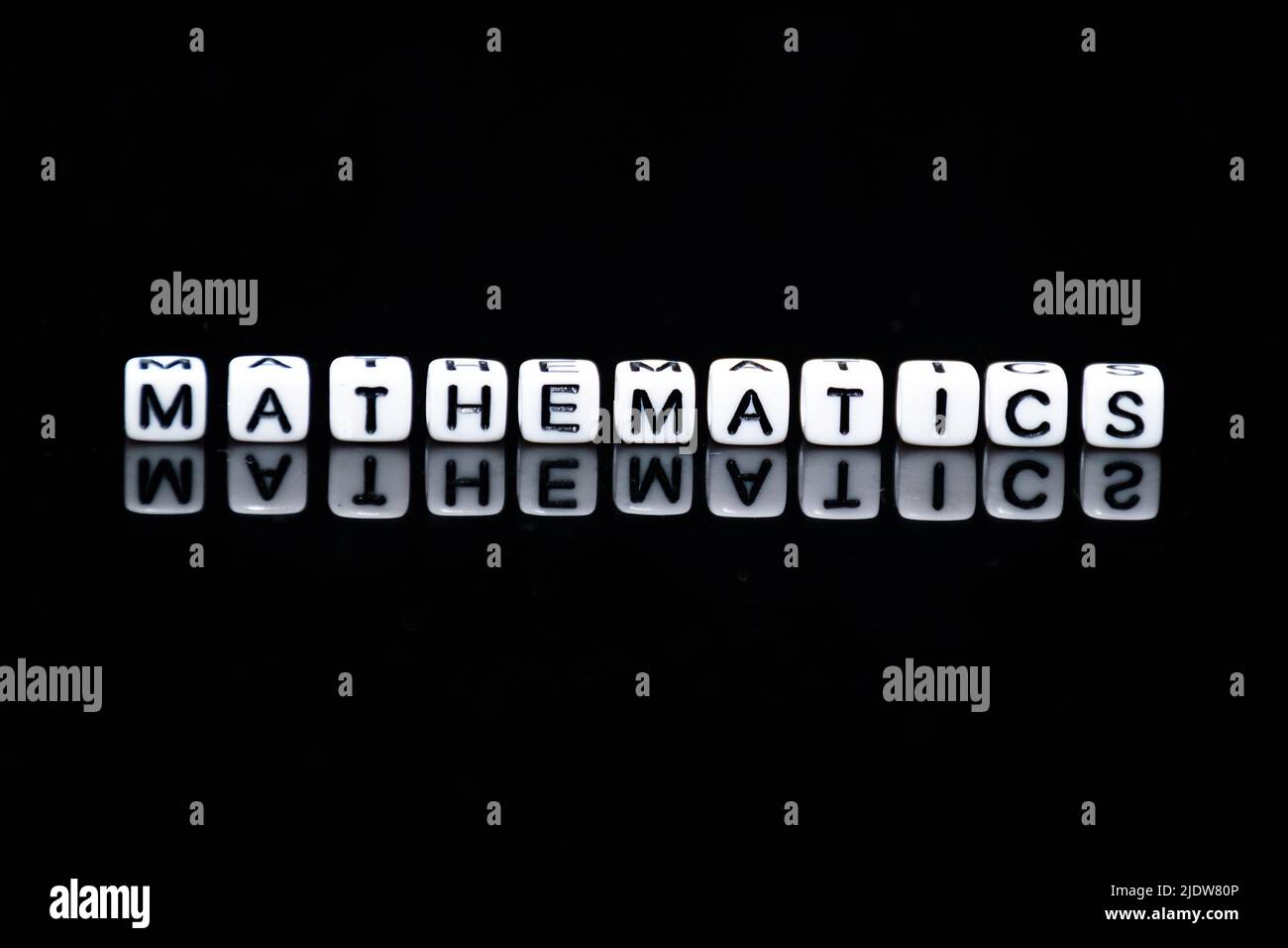 The word of 'MATHEMATICS' making from little acrylic cubes in black background. Stock Photo