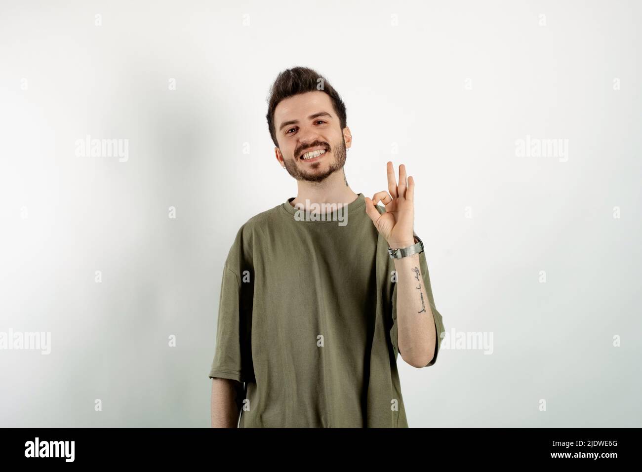 Happy casual man wearing t-shirt posing isolated over white background ...