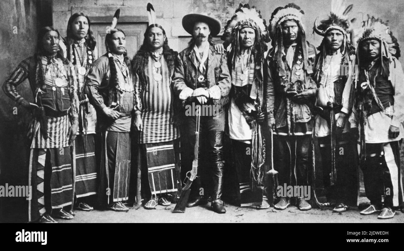 1890 ca., USA  : Colonel William Frederick CODY , know as BUFFALO BILL ( 1846 -1917  )  at time of WILD WEST SHOW  tour . SIOUX warriors, right , had once fought for the U. S. Cavalry. The Sioux Chef ROCKY BEAR as the third from right in the photo.  - Epopea del Selvaggio WEST - cowboy -  PONY EXPRESS - cow-boy - cappello - hat - Circo Barnum  -  baffi - barba  -  beard - moustache -  foulard - bandanna - stivali - boots - born native americans - pellerossa - pellirossa - feathers hat - copricapo di piume - indiani d' America    ----  Archivio GBB Stock Photo