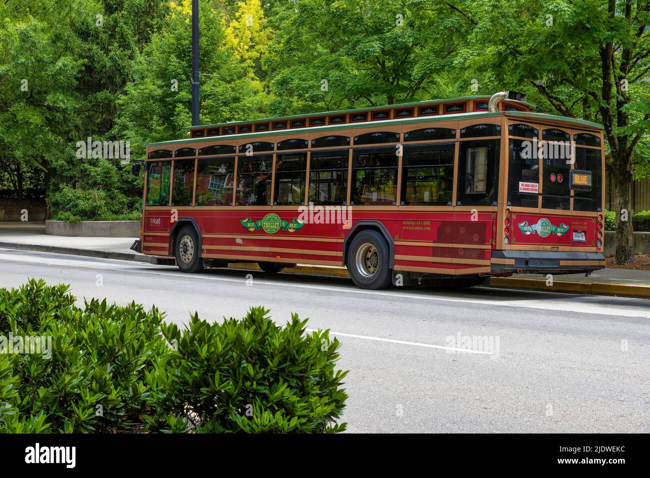 Knoxville, Tennessee, USA - May 28, 2022:  A trolley transportation bus sits parked on side of street in downtown Knoxville. Stock Photo
