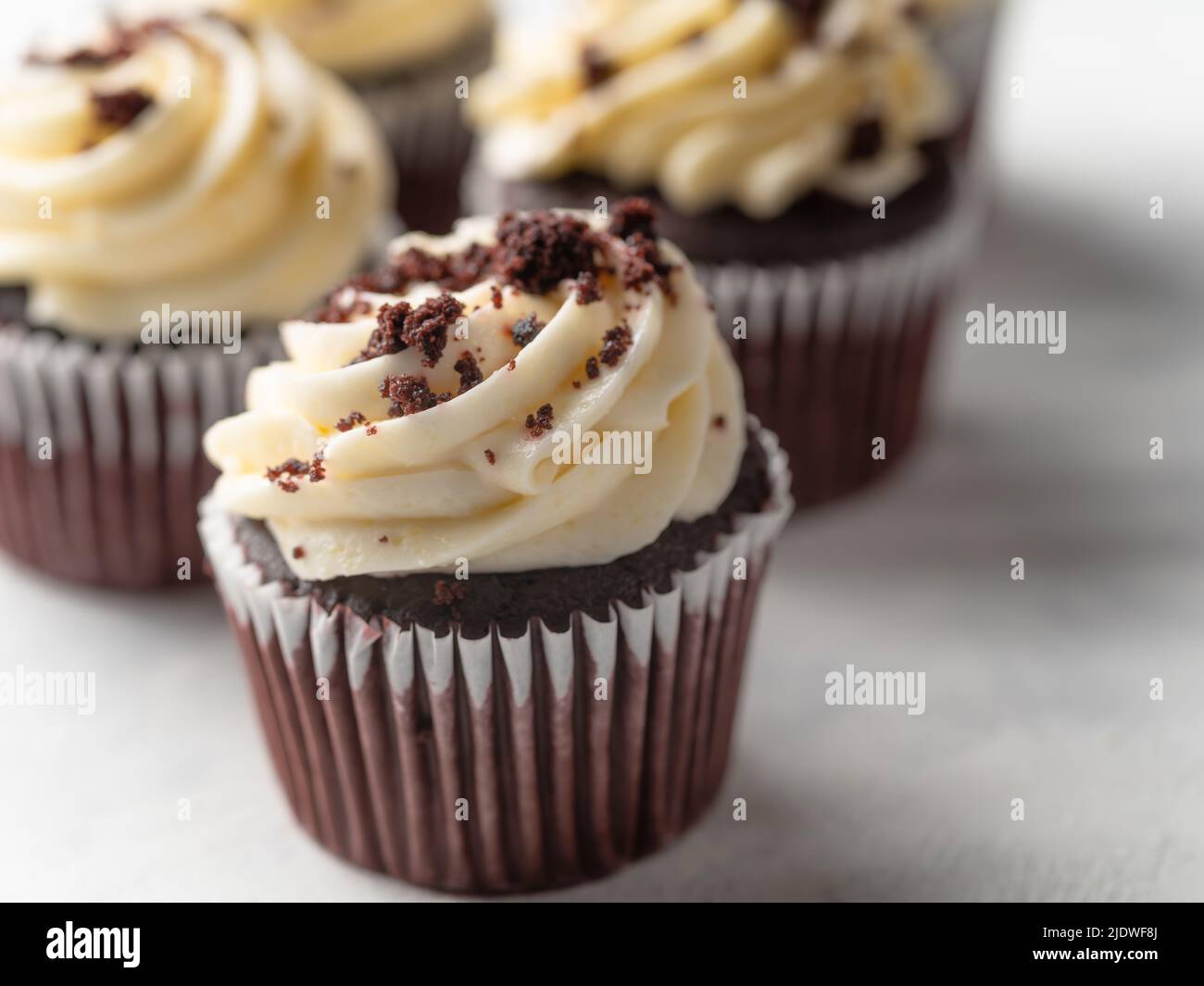 Close-up. Chocolate muffins with whipped cream and garnished with ...