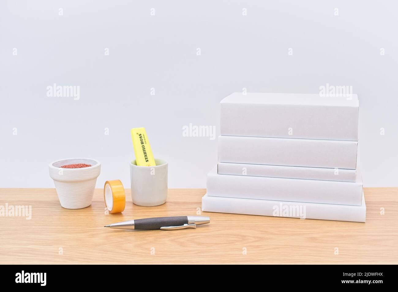 bright wooden office desk with consumables, books and supplies with